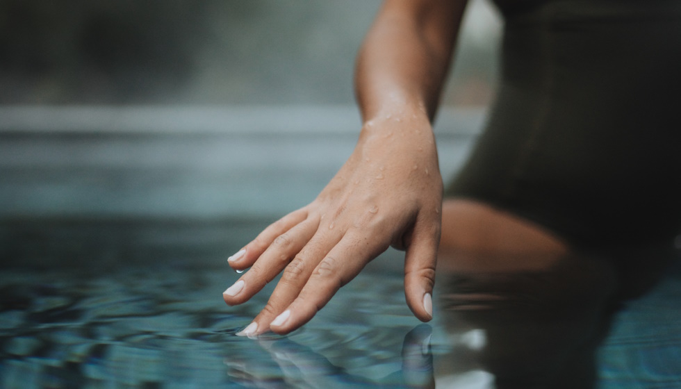 main dans un bassin d'eau thermale