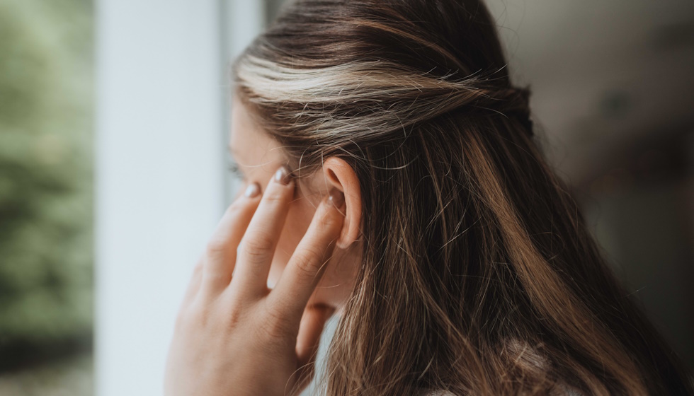 Femme qui se touche l'oreille