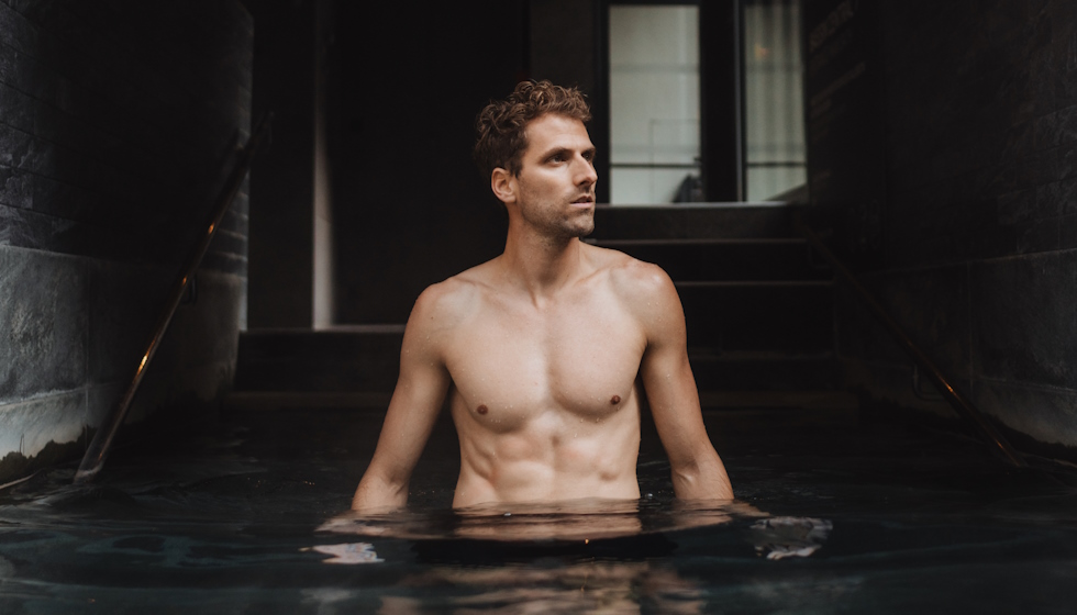 Homme entrant dans un bassin d'eau thermale