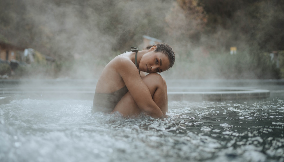 Femme dans une brume sur un bassin d'eau thermale à l'extérieur