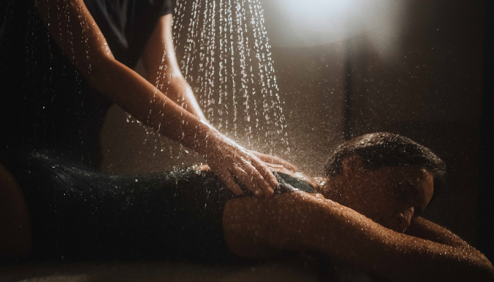 Femme recevant un massage sous affusion d'eau thermale