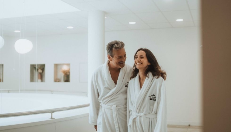Couple souriant en peignoir en mini cure thermale