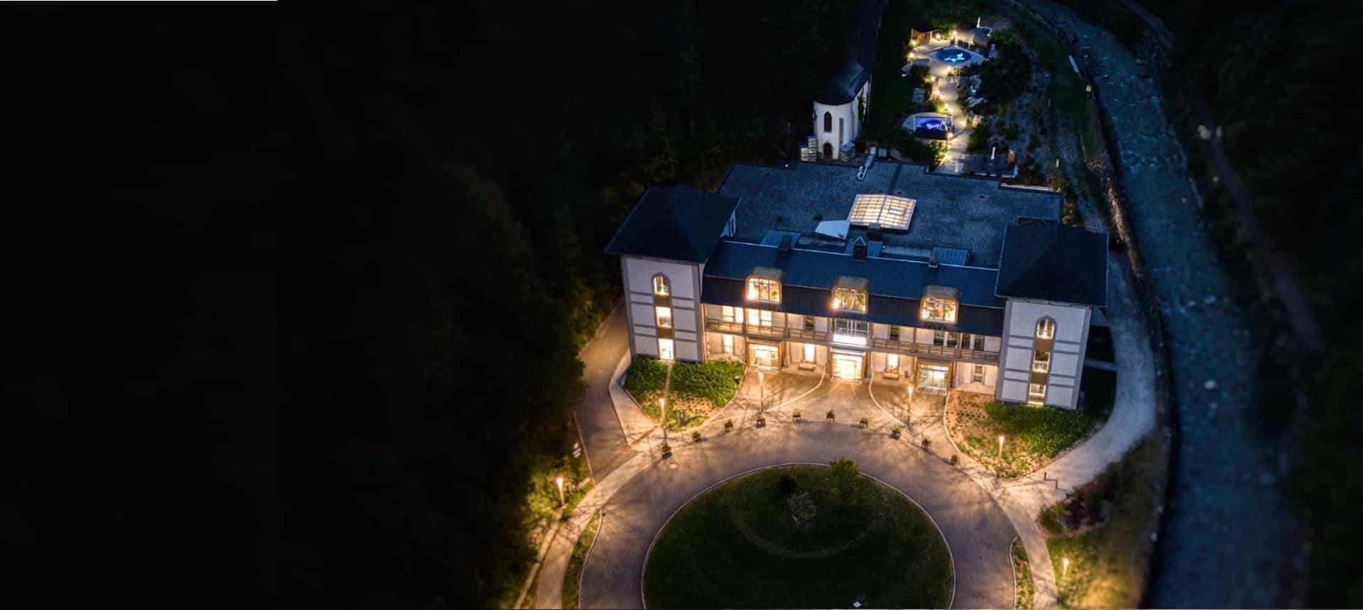 Vue aérienne des Thermes de Saint-Gervais-les-Bains illuminés à la nuit tombée.
