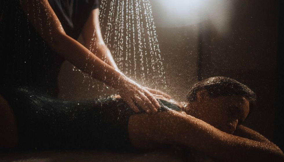 Femme profitant d'un massage sous affusion d'eau thermale