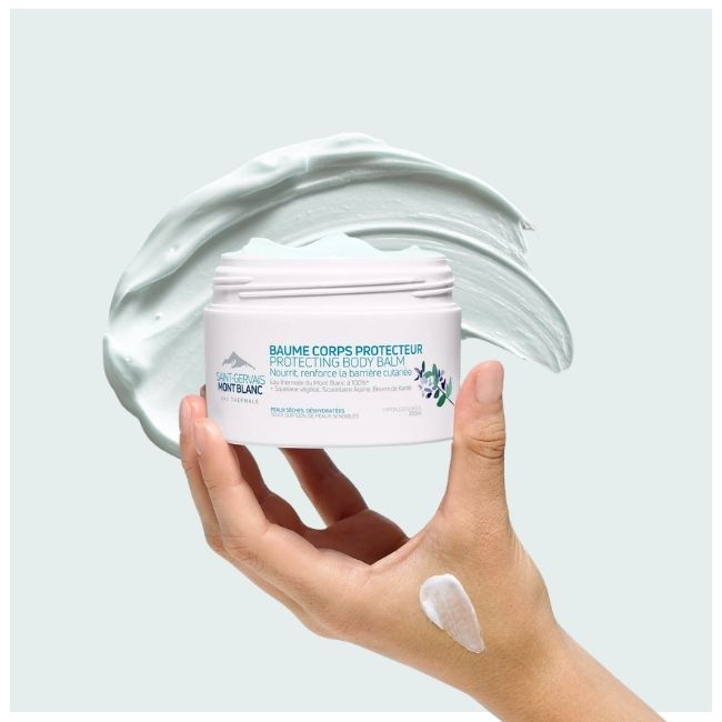 Main tenant le Baume corps fondant Saint-Gervais Mont Blanc  sur fond de texture de crème